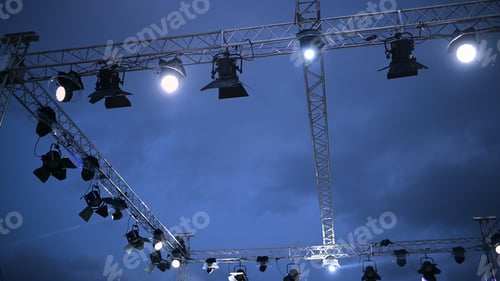 Preview: Stage lights suspended above a performance space create an ambiance during an evening event in an