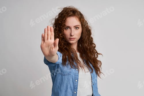 Preview: Young woman with red hair showing stop sign