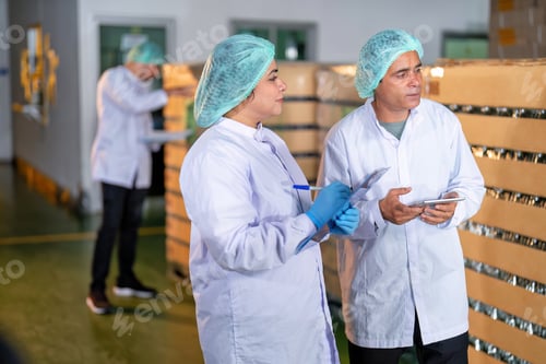 Preview: In warehouse quality control team checking drinking bottle stack on pallet before delivery