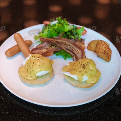 Preview: Egg benedict isolated on a plate with salad and sausage