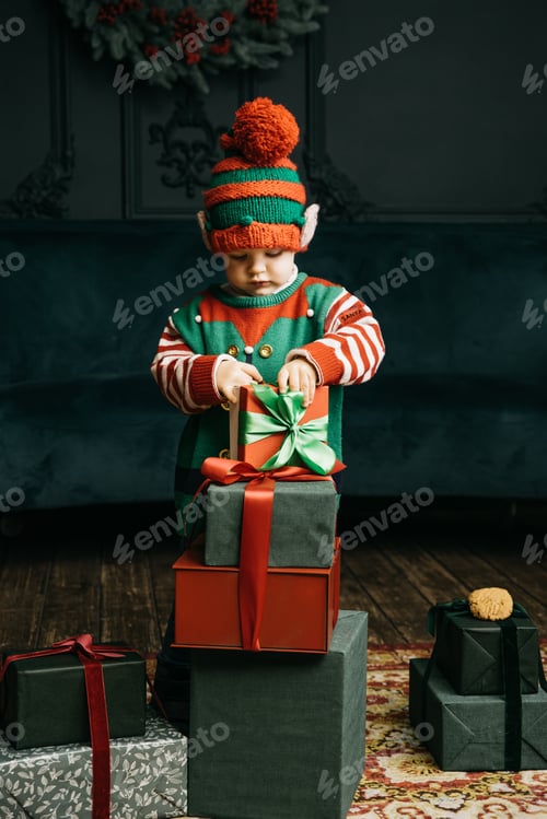 Preview: Little child under Christmas tree. baby boy in Santa Claus hat with gifts under Christmas tree with