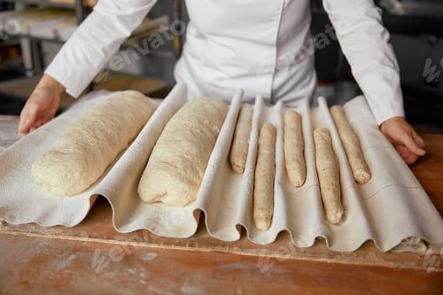 Preview: Woman baker or pastry cook making fresh bread in local bakery