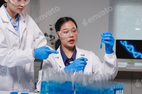 Preview: Scientists analyzing blue liquid in test tube in laboratory