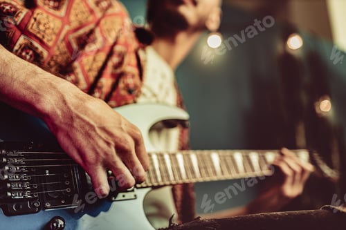 Preview: Close up of male hand playing electric guitar in the dark