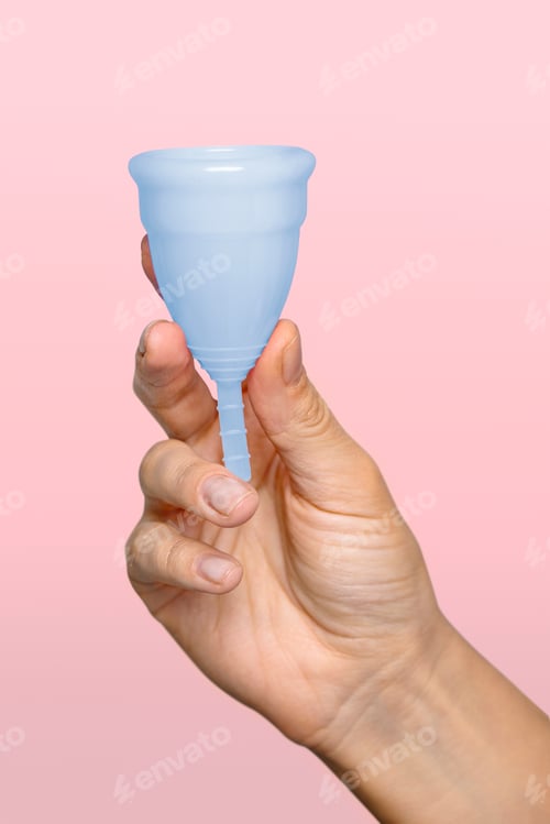 Preview: Hand holding blue menstrual cup