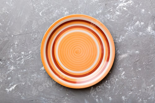 Preview: Top view of empty orange plate on cement background. Empty space for your design