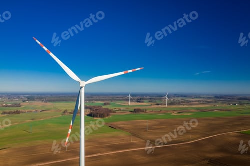 Preview: Flying above white wind turbines in a field in Poland