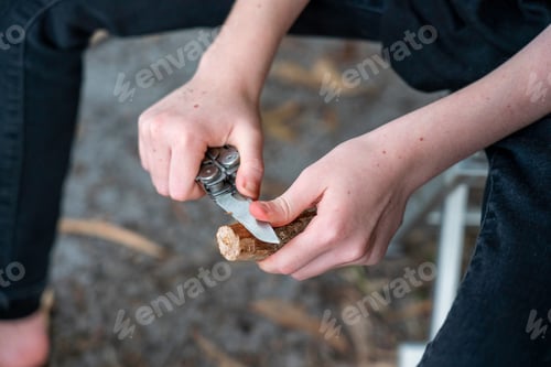 Preview: Child carving whittling a piece of wood with a knife