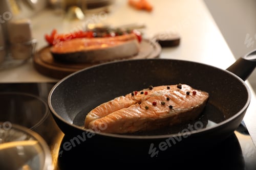 Preview: Frying pan with tasty salmon steak on cooktop
