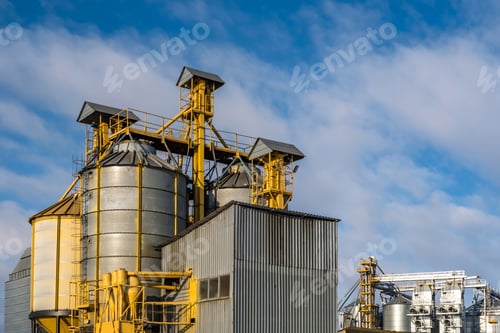 Preview: agro silos granary elevator in winter day in snowy field. Silos on agro-processing manufacturing