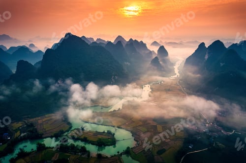 Preview: Sunrise over mountain range with foggy on rural village and river flows in Phong Nam Valley