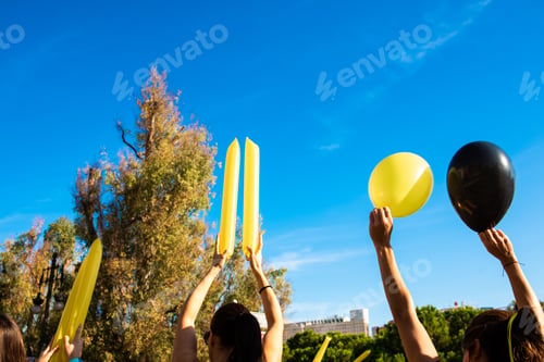 Preview: A girls cheer with colorful balloons by lifting them to the sky.
