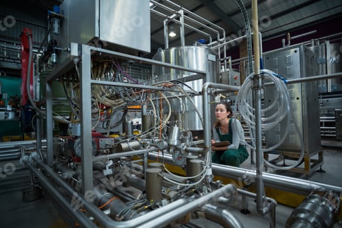 Preview: Female factory worker maintaining record on clipboard in factory