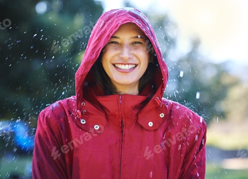 Preview: Dont let bad weather ruin your day. Shot of a young woman enjoying the rain outside.