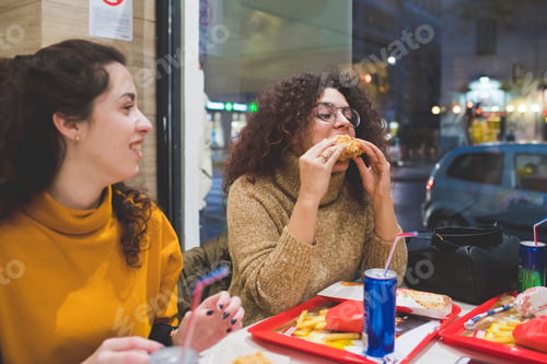 Preview: portrait of young woman eating together and having conversation