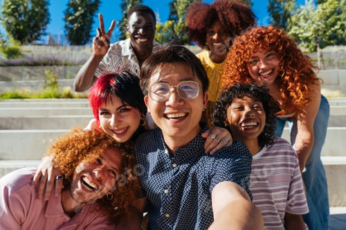 Preview: Multiethnic group of young friends meeting and having fun outdoors