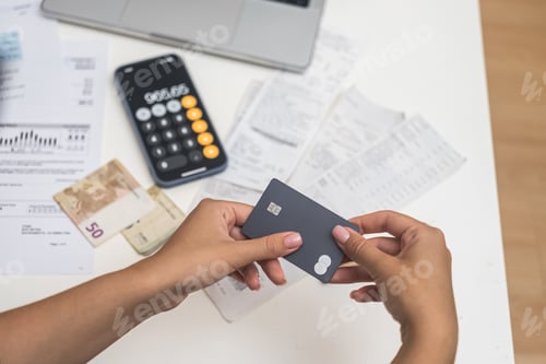 Preview: woman hold credit card to make quick payments for communal utilities through an online system.