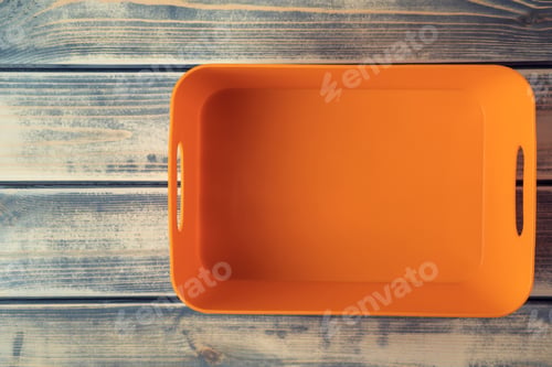 Preview: Orange empty plastic container, box on wood table background. Sustainable development, recycling and