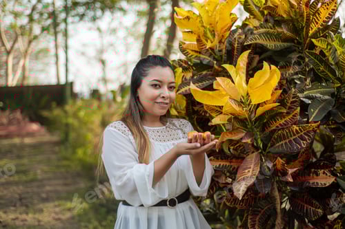Preview: Portrait of young woman next to garden plant.