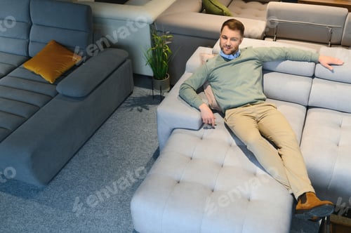 Preview: Young man buying sofa in furniture store