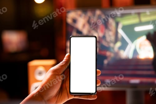Preview: Man in home using mockup mobile phone while enjoying FPS game, close up