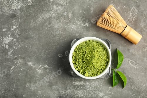 Preview: Matcha tea in bowl, whisk and green leaves on table, top view
