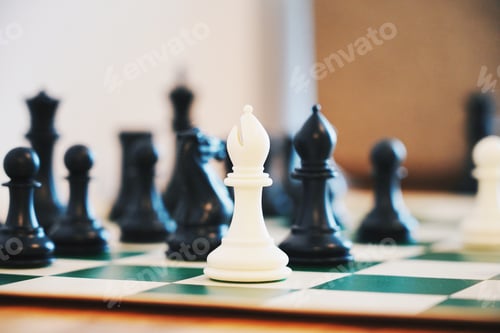 Preview: White bishop and black chess pieces on a board
