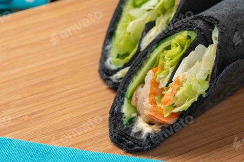 Preview: Tortilla wrap with shrimps and vegetables on wooden background