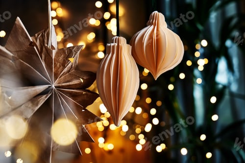 Preview: Handmade paper christmas decorations scandi style on branch on blurred christmas lights background.