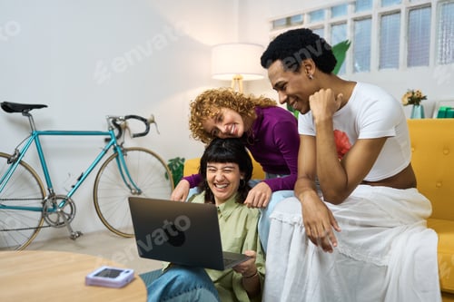 Preview: Happy lgtb friends laughing and watching a laptop at home