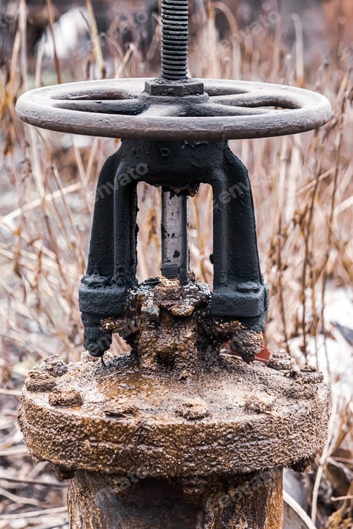 Preview: Big old rusty valve on pipe. Abandoned plumbing system.