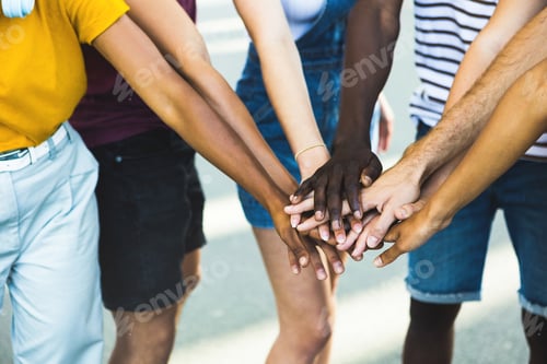 Preview: Diverse group of young people stacking hands together