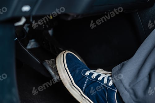 Preview: partial view of mechanic in sneakers pressing brake pedal in car