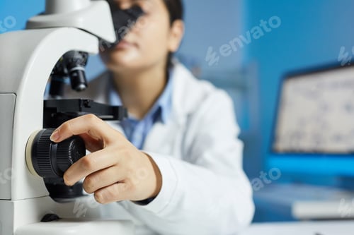 Preview: Scientist using adjustment knob of microscope