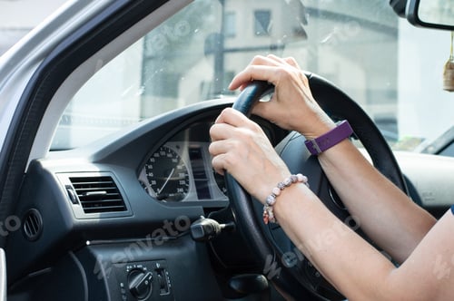 Preview: Hands on steering wheel. Woman driving a car