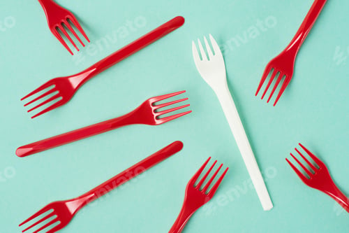 Preview: Top view of disposable plastic forks scattered on blue background
