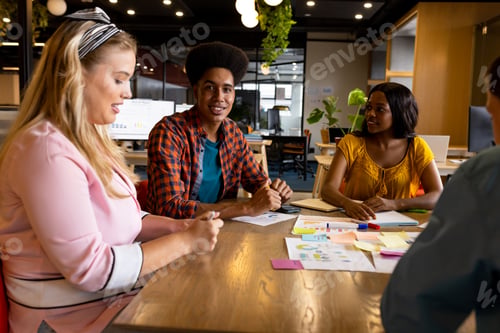 Preview: Diverse creative colleagues in discussion brainstorming using tablet and notes in office