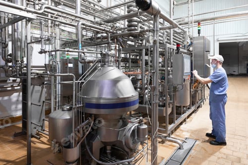 Preview: worker in a blue robe and a cap inspect the production department of dairy factory