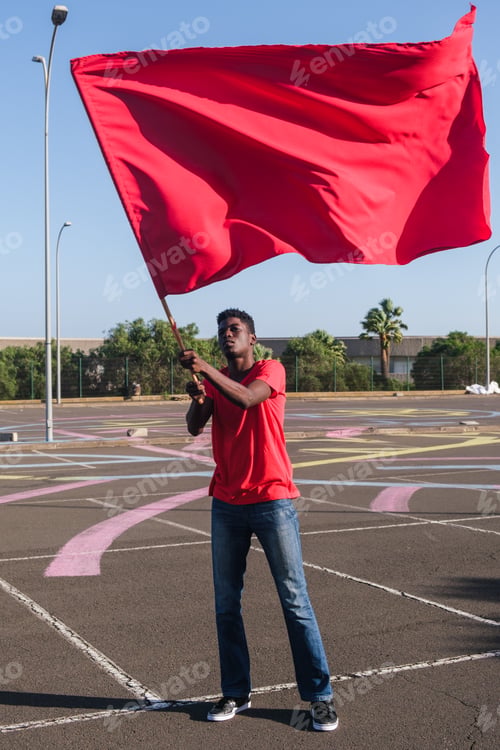 Preview: Young man waving his team's flag outdoors just before the big game