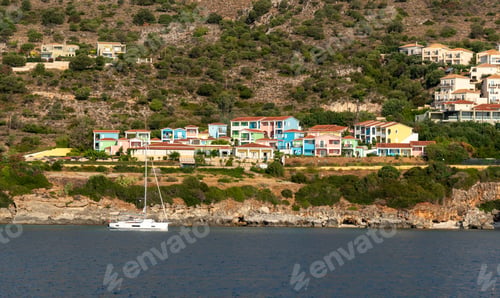 Preview: Sailboat anchored near colorful resort town in a greek island. Skala holiday resort Kefalonia Greece