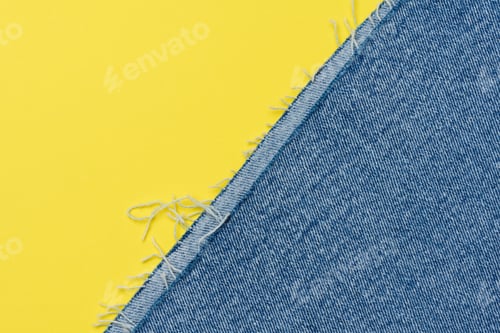 Preview: Torn edges of blue jeans on a yellow background