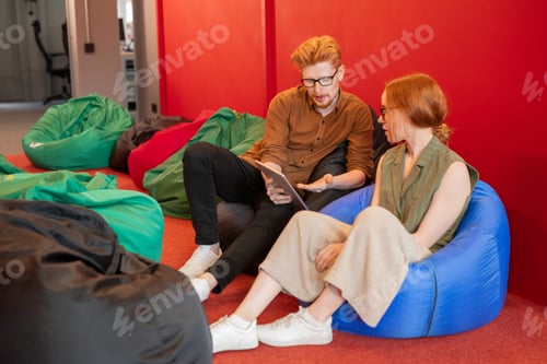 Preview: Young colleagues in casualwear discussing information for presentation points