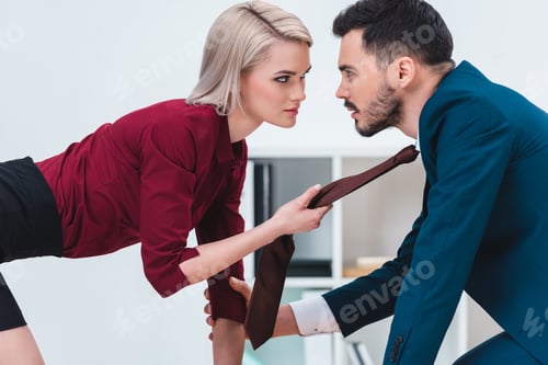 Preview: sexy young couple of business people looking at each other in foreplay at workplace