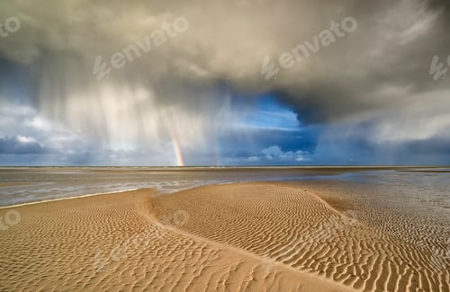 Preview: storm cloud and rainbow on sand beach