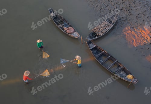 Preview: Top view of three unidentified men using fishing nets in shallow water