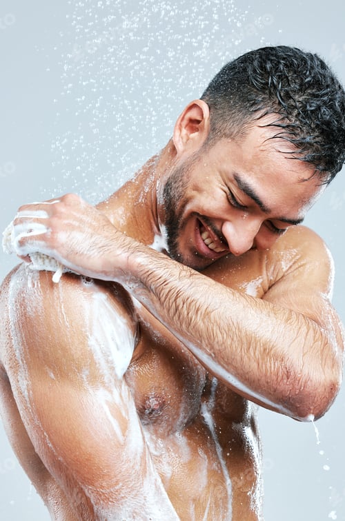 Preview: Studio shot of a handsome young man taking a shower against a grey background