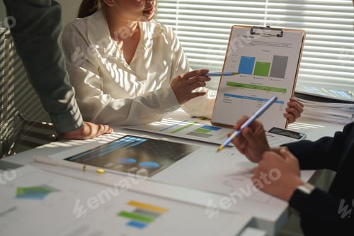 Preview: Business professionals analyzing financial charts and graphs that highlight market growth while util