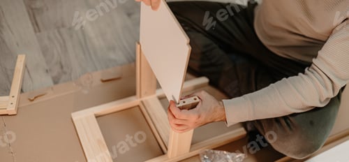 Preview: A man assembling new furniture bought for home