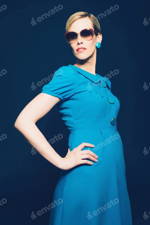 Preview: Portrait Of An Elegant Young Woman Posing In Blue Full Dress With Sunglasses, Looking To The Left