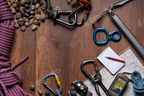 Preview: wooden table with climbing equipment, rope, carabiners, ice axe,